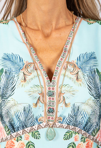 Close-up of a colorful dress with floral and palm tree patterns.