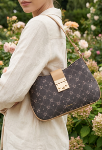 Person holding a patterned handbag with a garden in the background