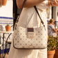 Person holding a patterned handbag with a blurred outdoor background