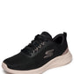 Black sneaker with beige sole on a white background