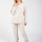 Woman wearing a beige tracksuit with a white background