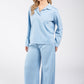 Woman wearing a light blue pajama set on a white background