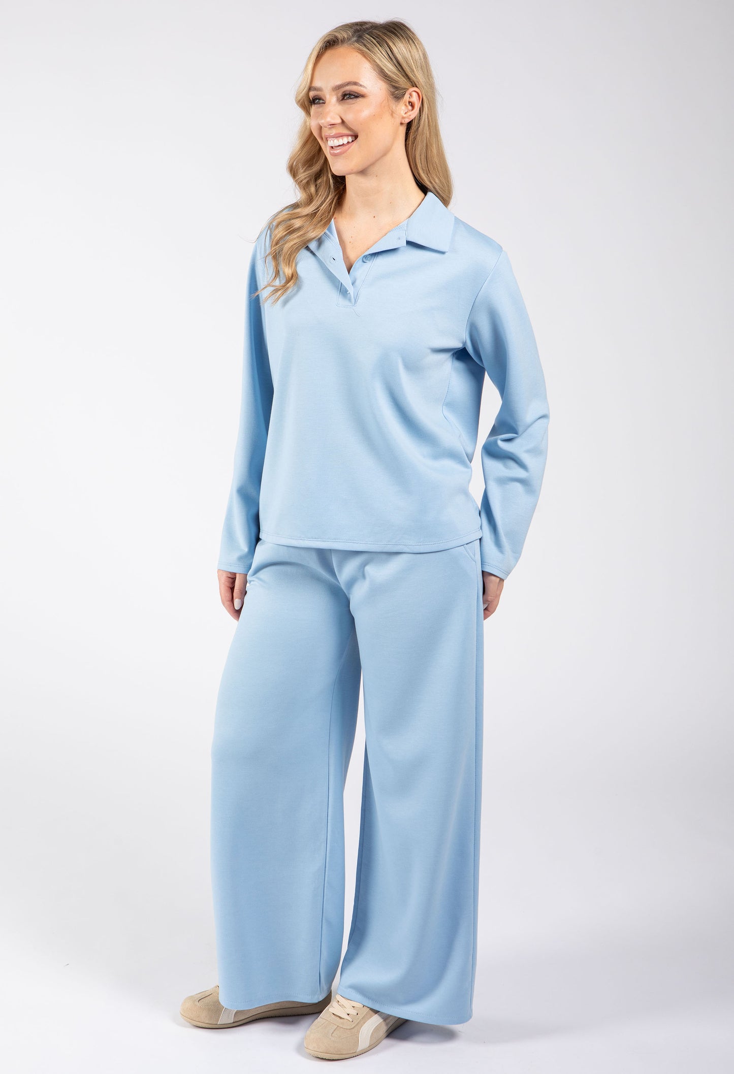 Woman wearing a light blue pajama set on a white background