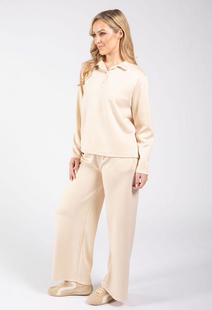 Woman wearing a beige pajama set on a white background