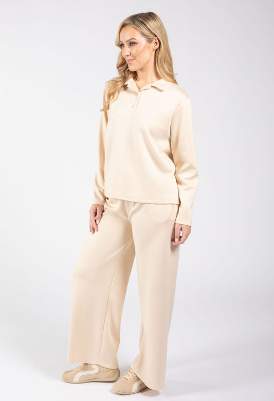 Woman wearing a beige pajama set on a white background