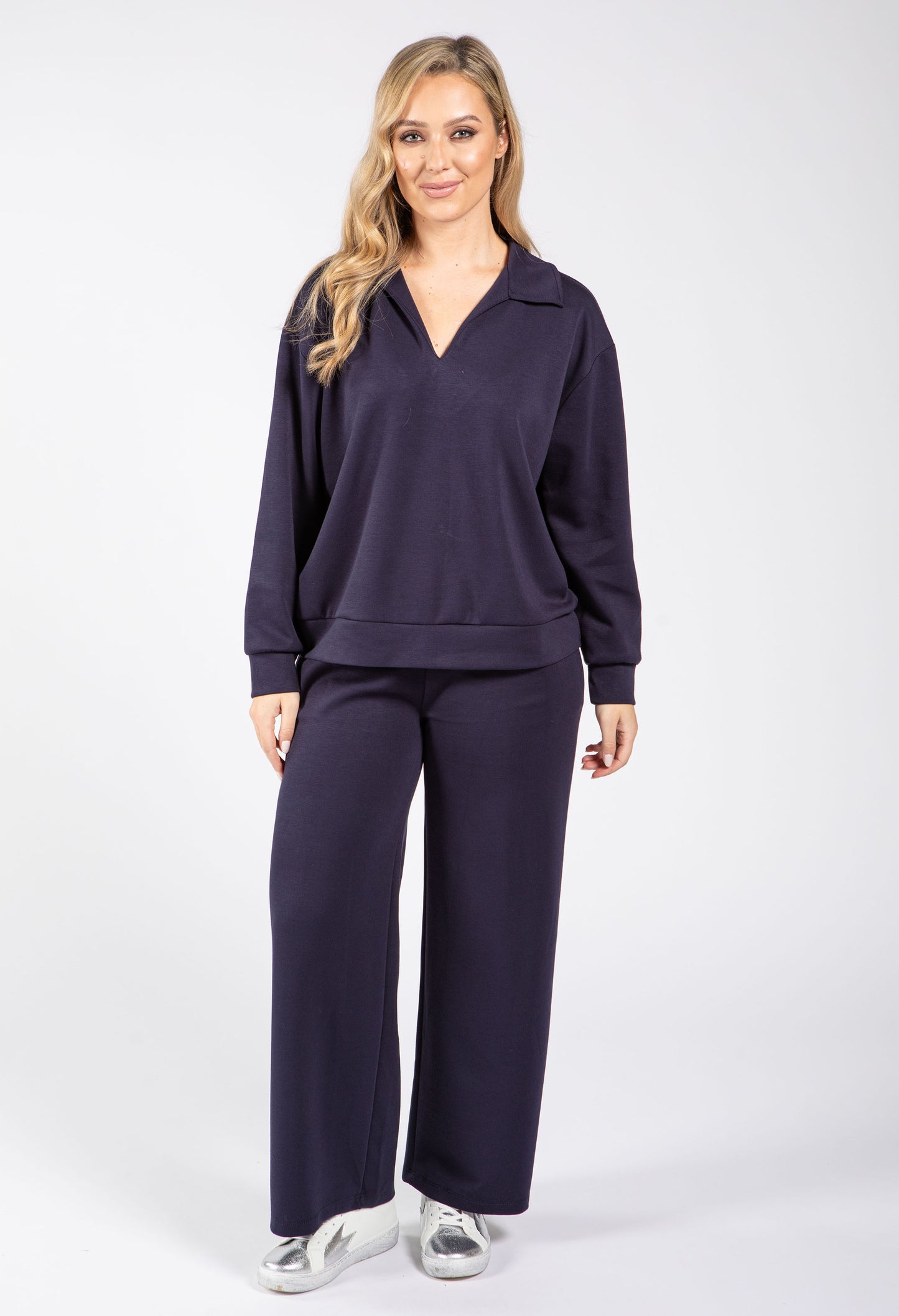Woman wearing a navy tracksuit on a white background