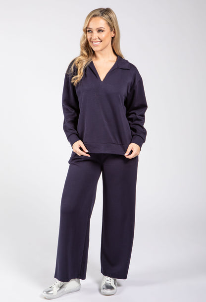 Woman wearing a navy blue outfit on a white background