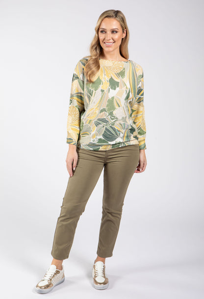 Woman wearing a floral patterned top and khaki pants on a white background