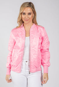 Woman wearing a pink bomber jacket on a white background