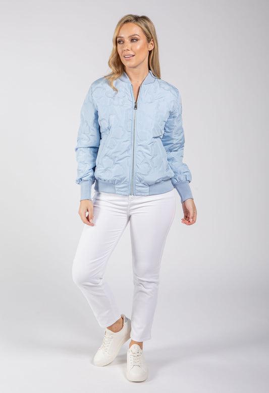 Woman wearing a beige bomber jacket on a white background