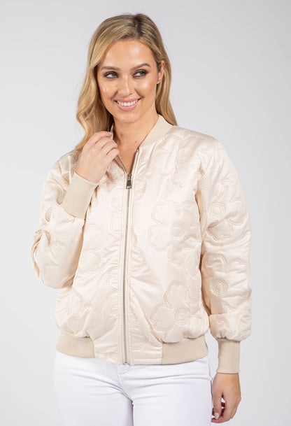 Woman wearing a beige bomber jacket on a white background
