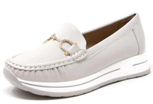 Navy blue patent leather loafer with a white sole on a white background