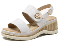White sandal with a gold buckle on a white background