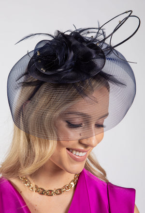 Woman wearing a black floral headpiece with a veil on a white background
