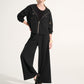 Person wearing a black outfit with wide-leg pants on a white background