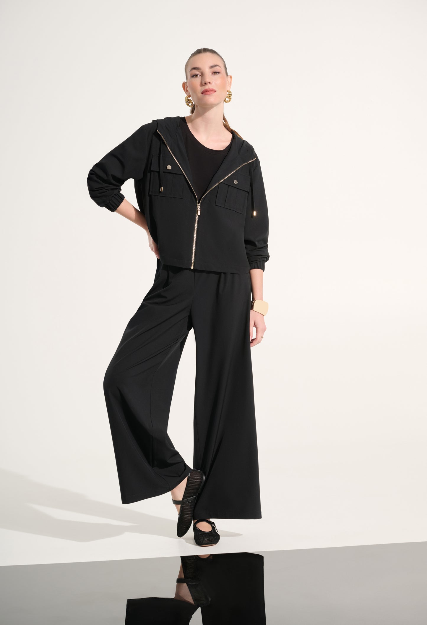 Person wearing a black outfit with wide-leg pants on a white background