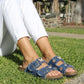 Person wearing blue sandals with floral patterns on grass