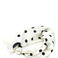White hair tie with black polka dots on a white background
