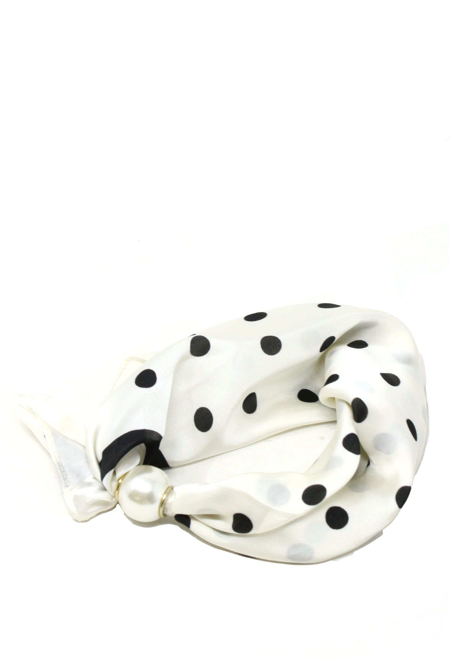 White hair tie with black polka dots on a white background