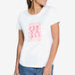 Woman wearing a white t-shirt with pink graphic design on a plain background