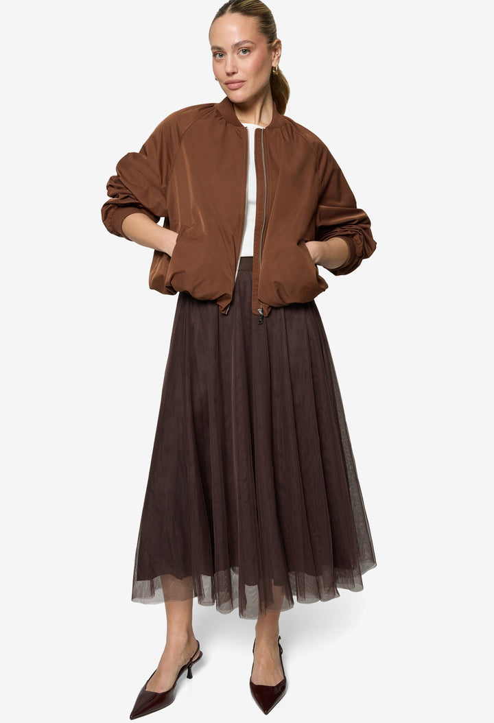 Woman wearing a brown jacket and skirt on a white background