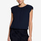 Woman wearing a black sleeveless navy with a plain background