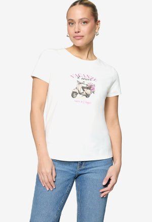 Woman wearing a white t-shirt with a graphic design on a plain background