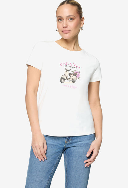 Woman wearing a white t-shirt with a graphic design on a plain background