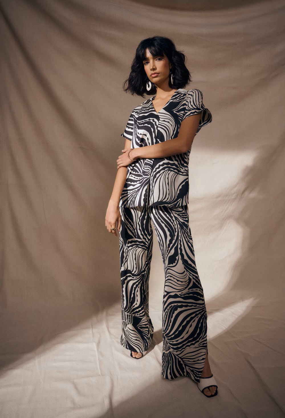 Woman wearing a zebra print outfit against a beige background