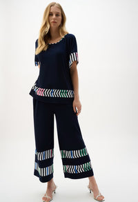Woman wearing a navy outfit with colorful patterns on a white background