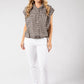 Woman wearing a checkered shirt and white pants on a plain background
