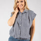Woman wearing a checkered shirt and denim shorts on a plain background