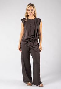 Woman wearing a brown jumpsuit on a white background