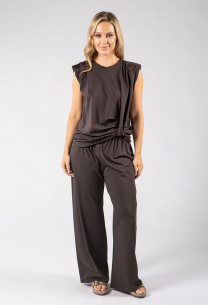 Woman wearing a brown jumpsuit on a white background