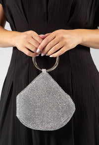 Silver beaded handbag held by a person wearing a black dress.