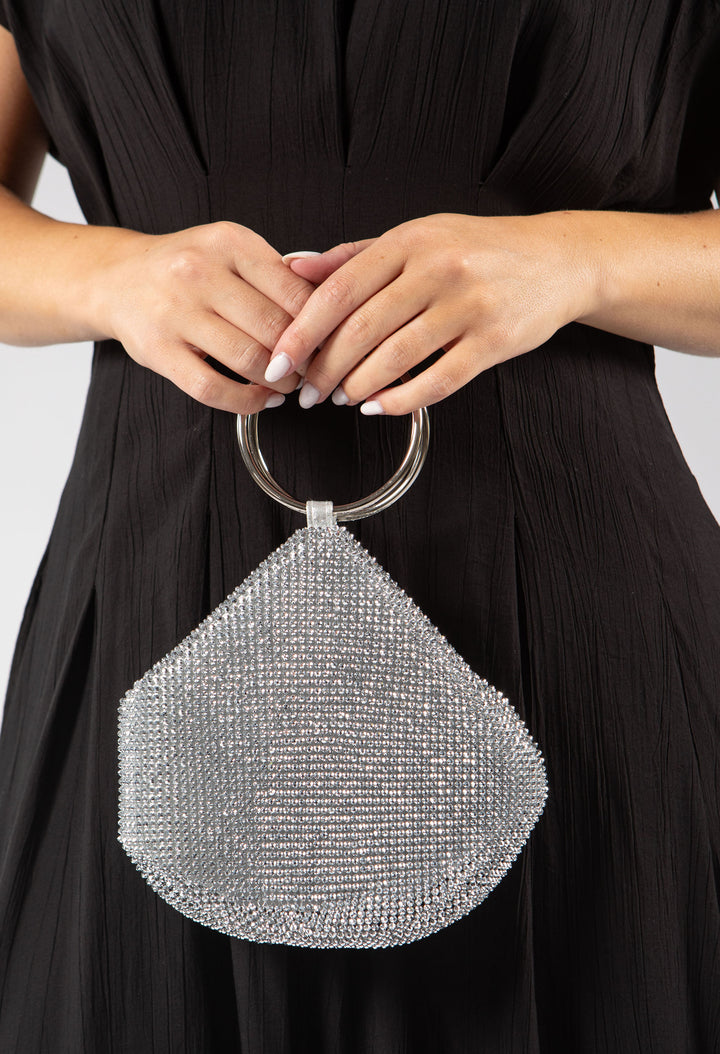 Silver beaded handbag held by a person wearing a black dress.