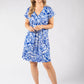 Woman wearing a blue and white patterned dress on a white background