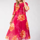 Woman wearing a pink dress with orange floral patterns on a white background