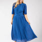 Woman wearing a blue pleated dress on a white background