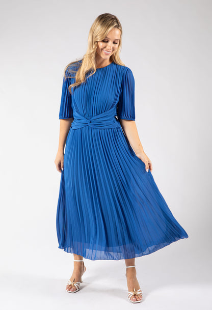 Woman wearing a blue pleated dress on a white background