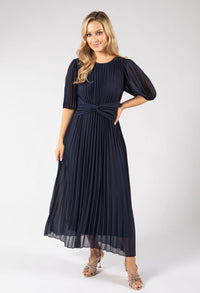Woman wearing a navy blue dress with puff sleeves on a white background