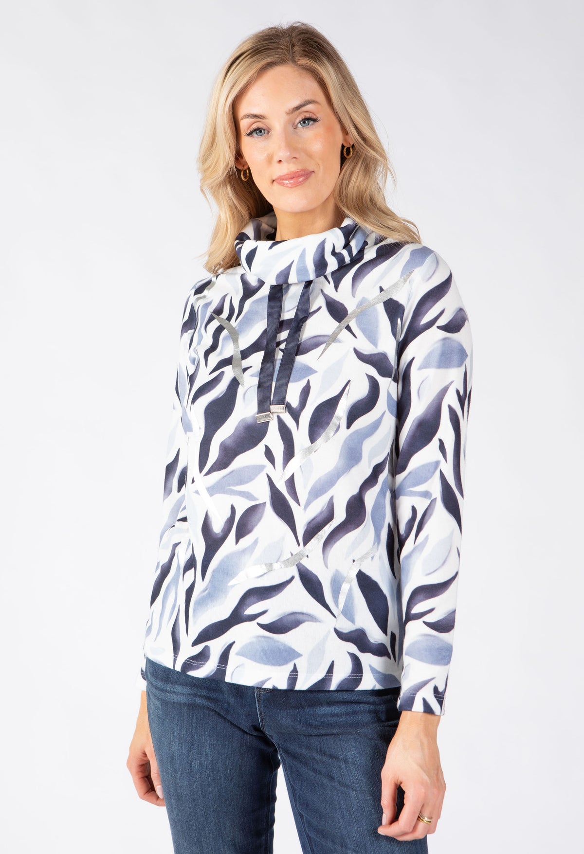 A woman modeling a long-sleeve hooded top with a white, light blue, and dark navy abstract leaf pattern.