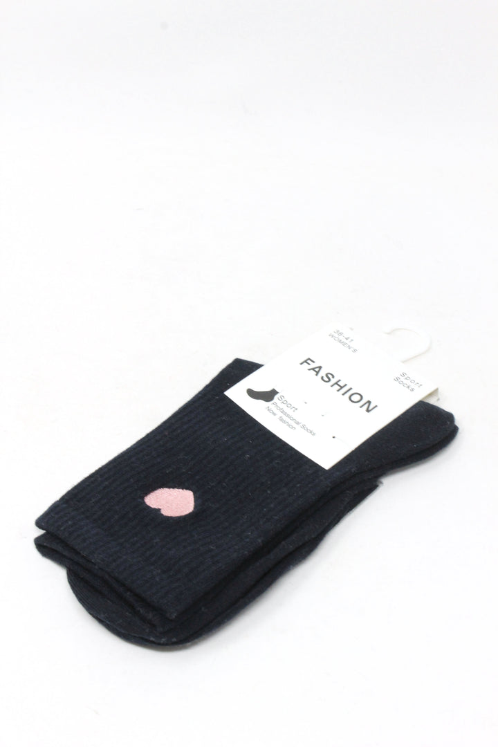 A pair of black ribbed knit socks folded together with a white paper tag attached, featuring a small pink heart detail on one sock, set against a plain white background.