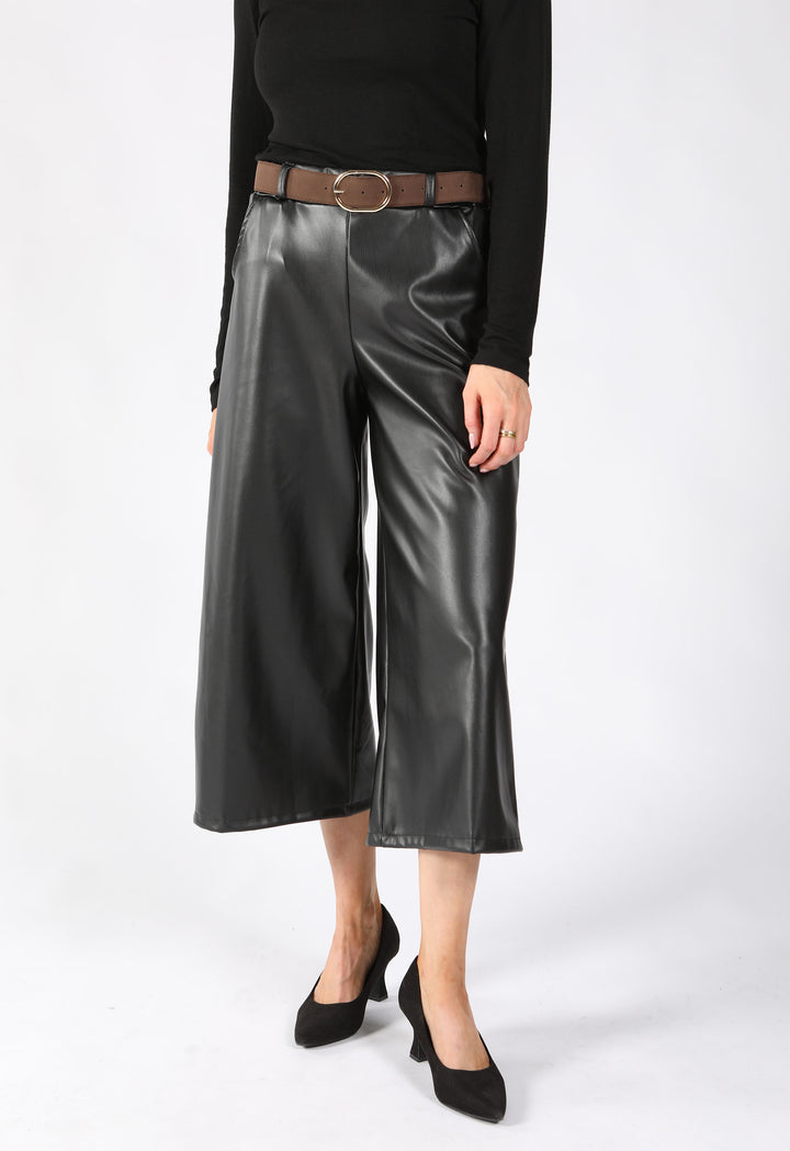 Model wearing culottes in premium black faux leather with front pockets.