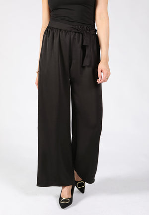 A model wearing black wide-leg trousers with a matching fabric tie belt at the waist.
