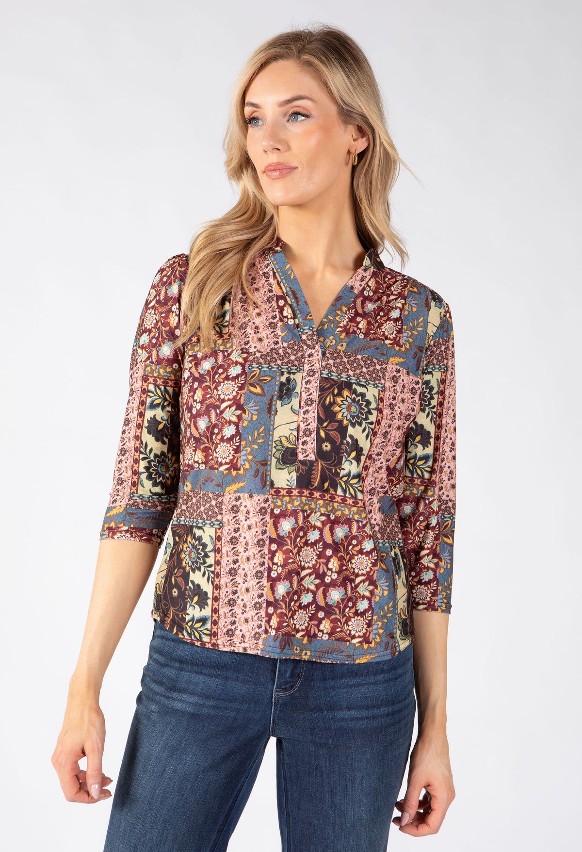 A woman modeling a three-quarter sleeve button-up blouse with a multicolor patchwork paisley print.