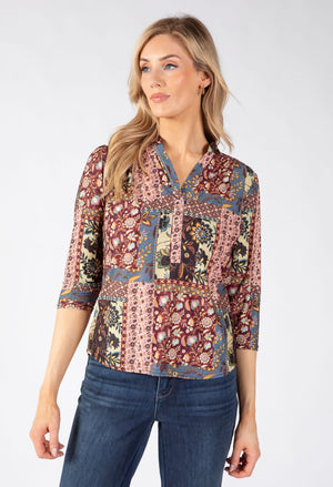 A woman modeling a three-quarter sleeve button-up blouse with a multicolor patchwork paisley print.