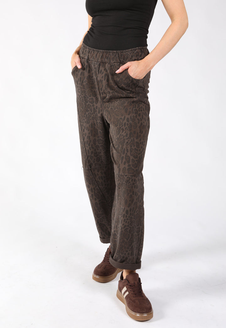 A person wearing dark brown leopard-print pants with a balloon leg style.