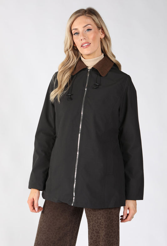 A woman modeling a black hooded jacket with a brown collar, featuring a silver zipper and front pockets.