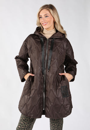 A woman modeling a dark brown quilted hooded jacket with a front zipper, black drawstrings, and a kangaroo pocket.